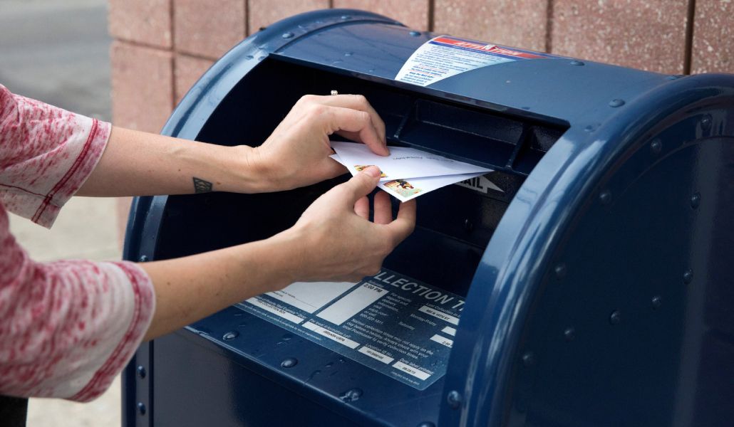 Foto de recurso de una persona dejando unas cartas en el buzón