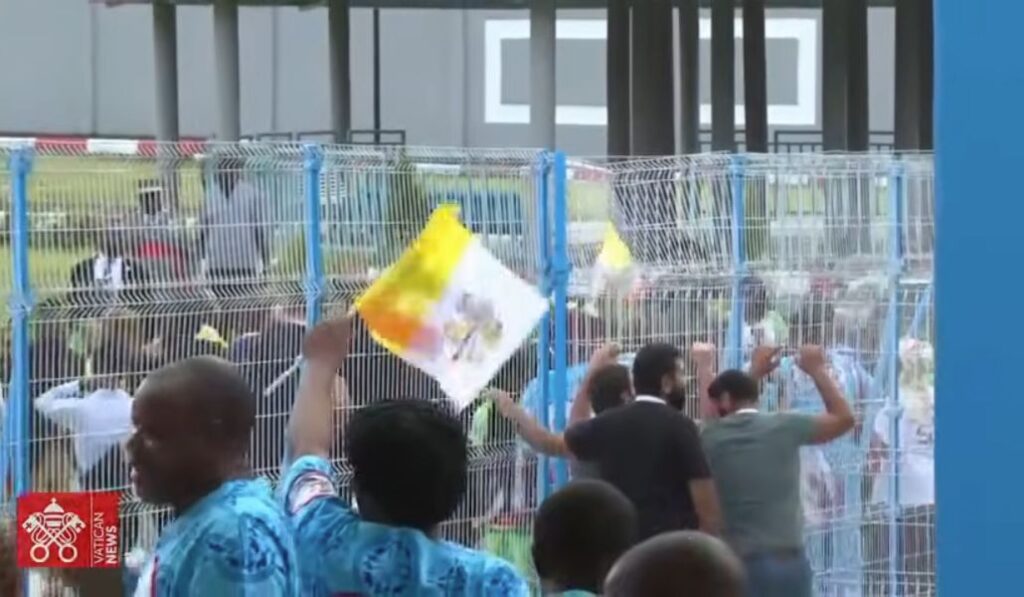 Muchedumbre con banderas de Guinea Ecuatorial y del Vaticano.