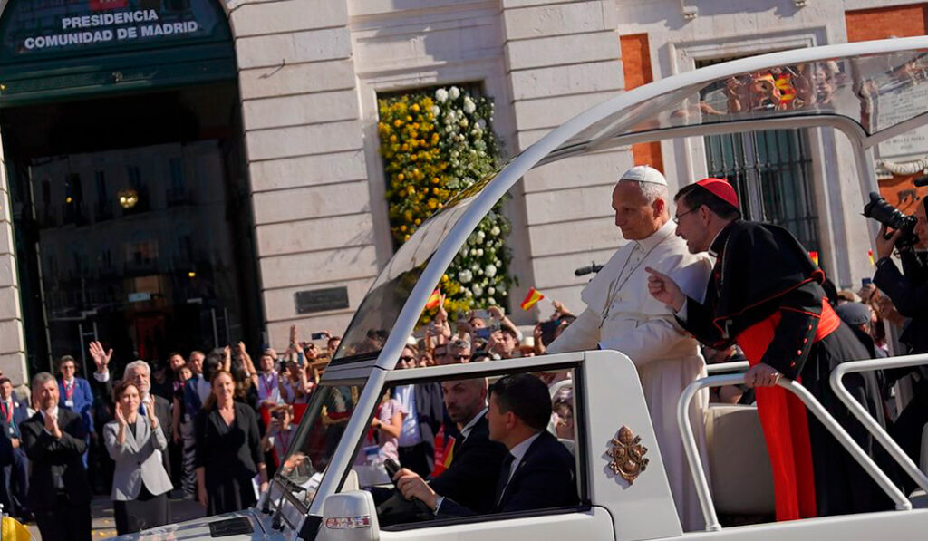 León XIV con el cardenal Cobo pasan con el papamóvil por delante de la Casa de Correos.