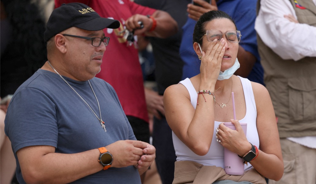 Una familia llora frente a las ruinas de su casa en Caracas.