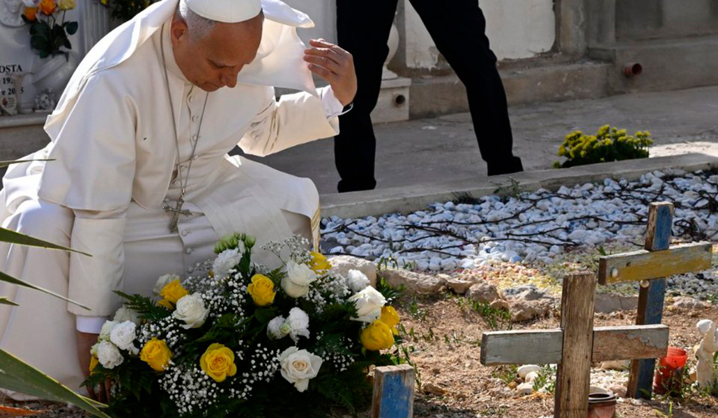 El Papa coloca una corona de flores en las tumbas de los migrantes.