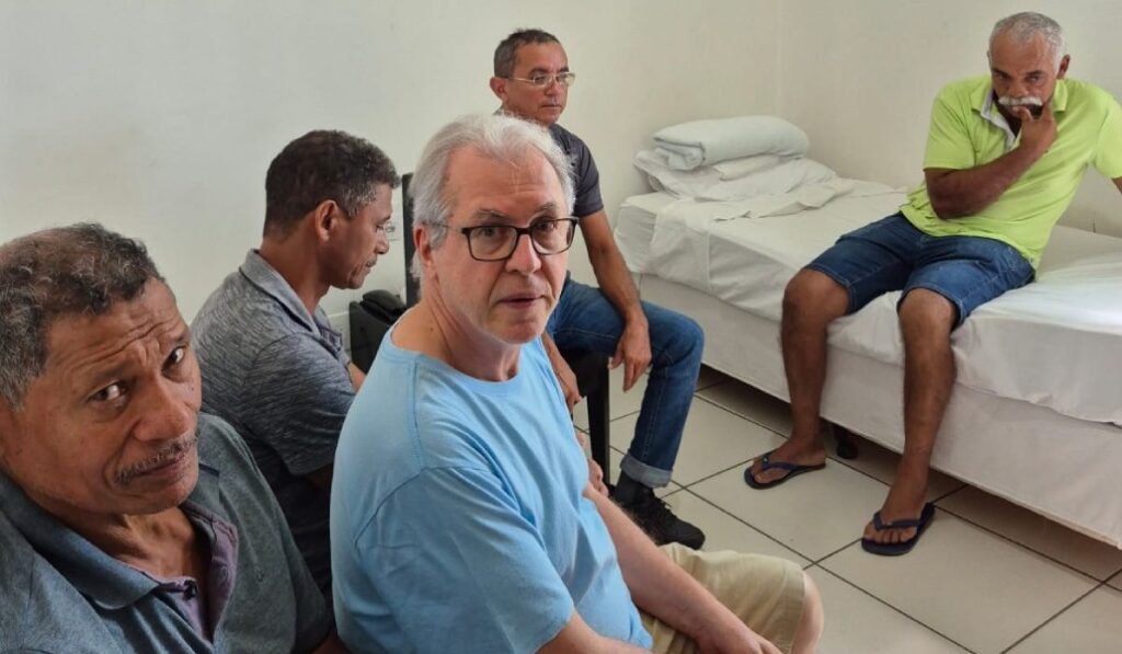 El sacerdote brasileño Ricardo Rezende con trabajadores que vivían en régimen de esclavitud en una granja.