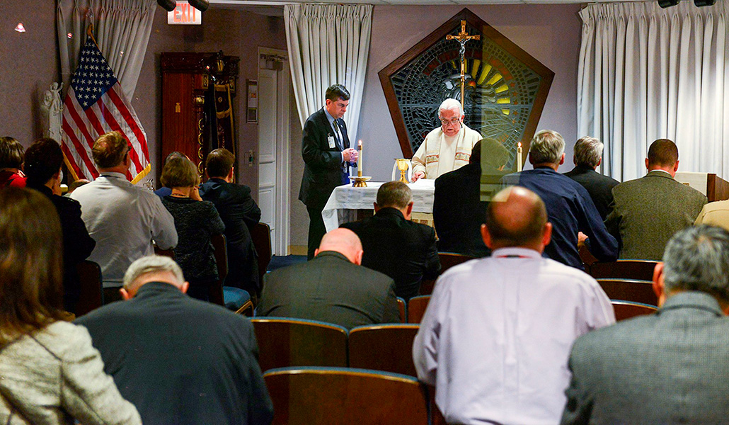 El padre John Davis celebra misa, asistido por un voluntario, en la Capilla Conmemorativa del Pentágono en Arlington, Virginia, durante el Día Nacional de Oración el 5 de mayo de 2016.