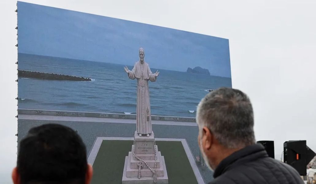 Personas observan una pantalla con la imagen de lo que será la escultura del papa León XIV que se erigirá frente al océano Pacífico, en Callao (Perú).