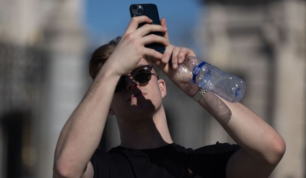 Un joven utiliza un smartphone por la calle.