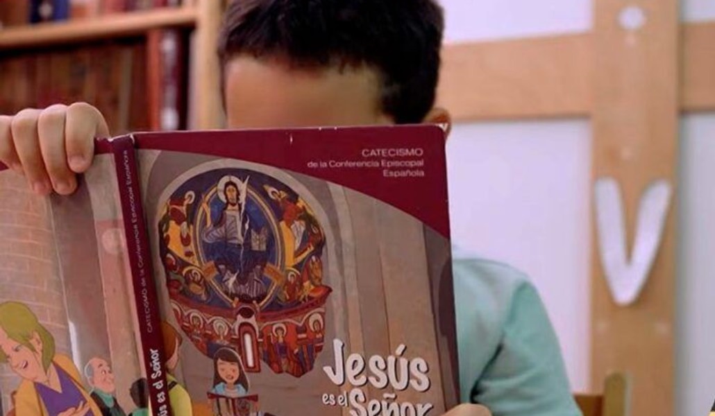 Un niño lee el catecismo 'Jesús es el Señor'.